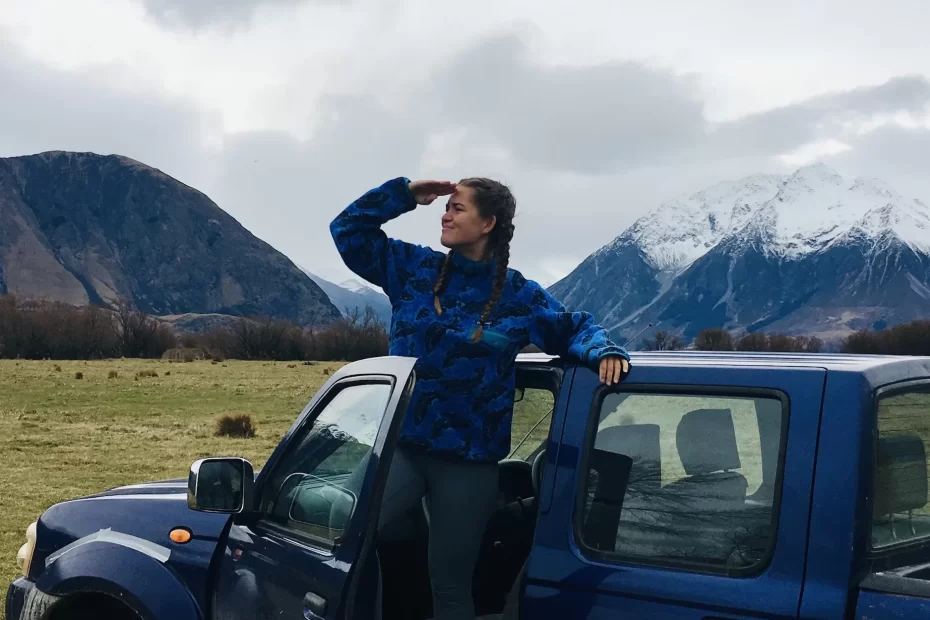 niki stands out the door of a truck overlooking mountains