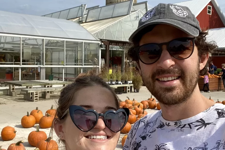 niki and ben in front of a pumpkin patch
