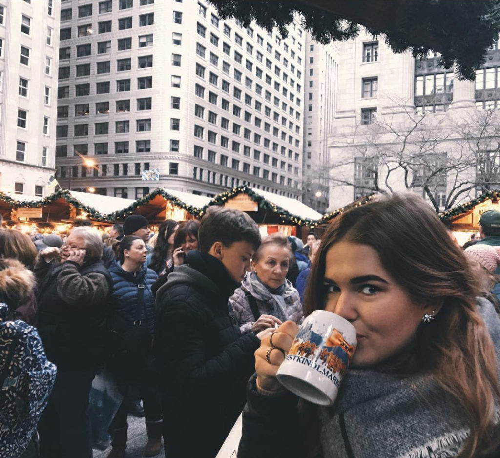 things to do in chicago in winter: niki sips a hot drink at christkindlmarket