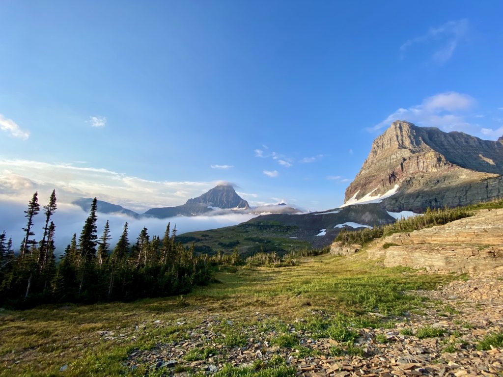 glacier national park itinerary: foggy hiking trail with rugged mountains