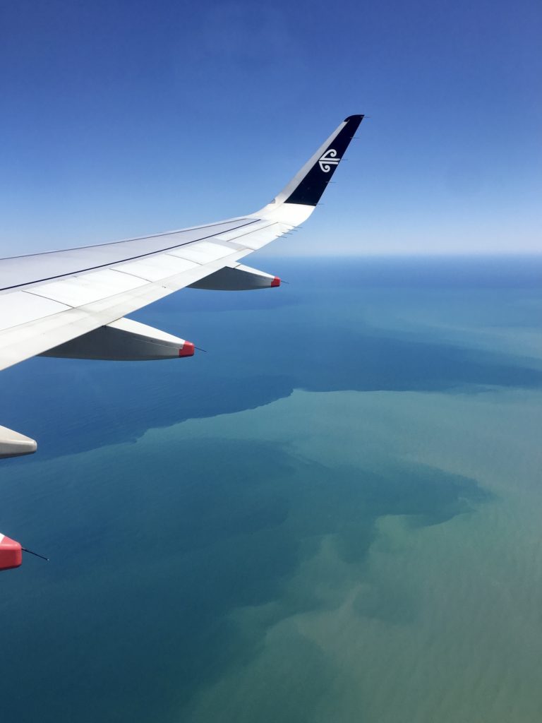 best new zealand travel apps: air new zealand airplane wing over the ocean