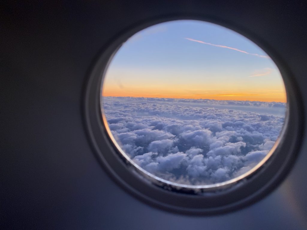 post-covid travel: my thoughts & predictions -- view of sunset and clouds from an airplane window