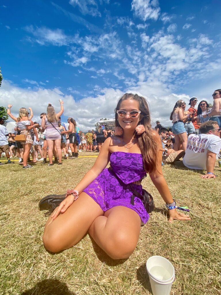 bay dreams: niki sits on the ground in a purple rave outfit