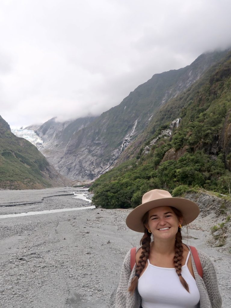 what to know before moving to new zealand: niki stands in front of franz josef glacier