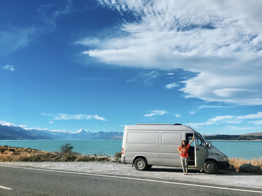 niki poses with the van in front of lake pukaki, new zealand