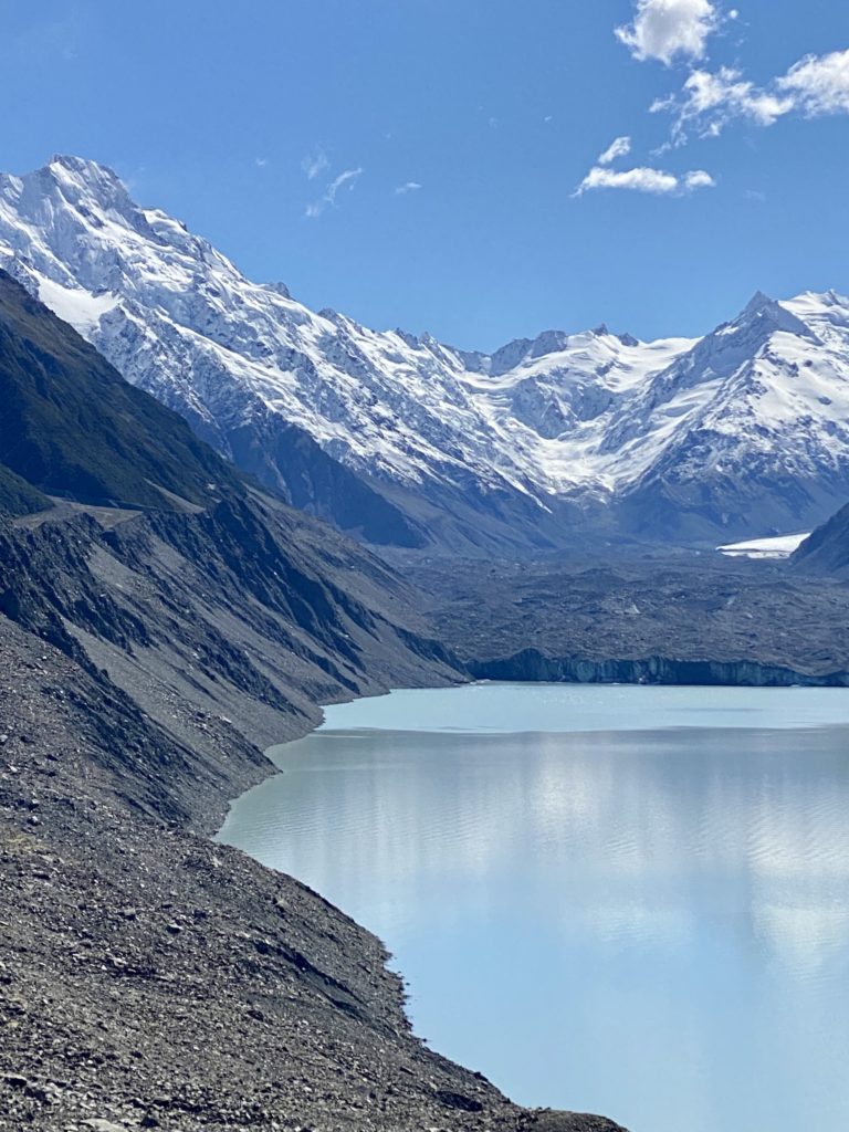blue lakes and tasman glacier: snow-covered mountains behind a big blue lake