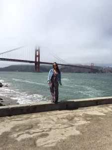 San Francisco travel guide: Niki stands in front of the Golden Gate Bridge with fog in the background