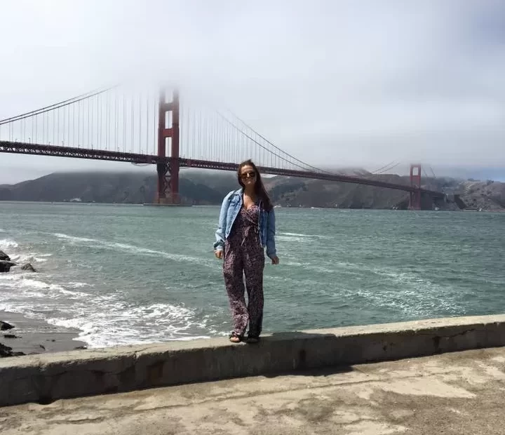 San Francisco travel guide: Niki stands in front of the Golden Gate Bridge with fog in the background