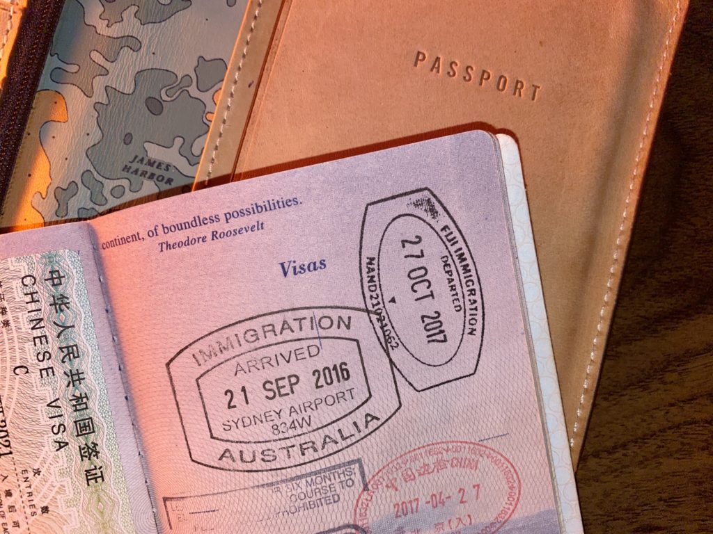 How to plan a trip: passport stamps in front of a passport case
