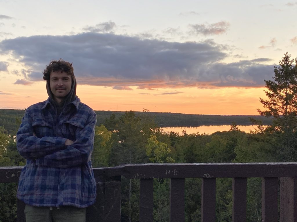 Ben stands in front of the sunset, Michigan's Upper Peninsula