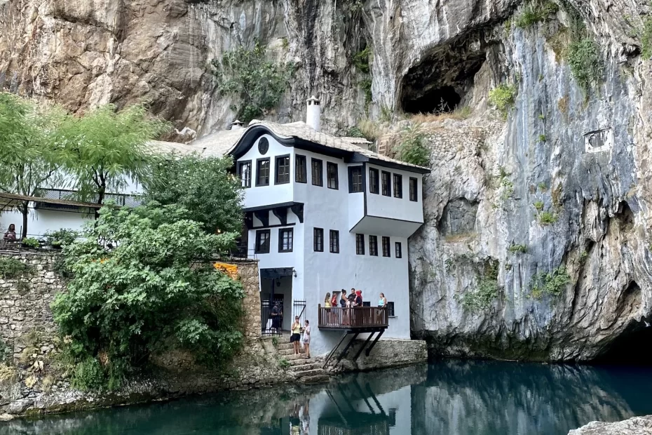 Blagaj Monastery in front of natural spring water and cliffs