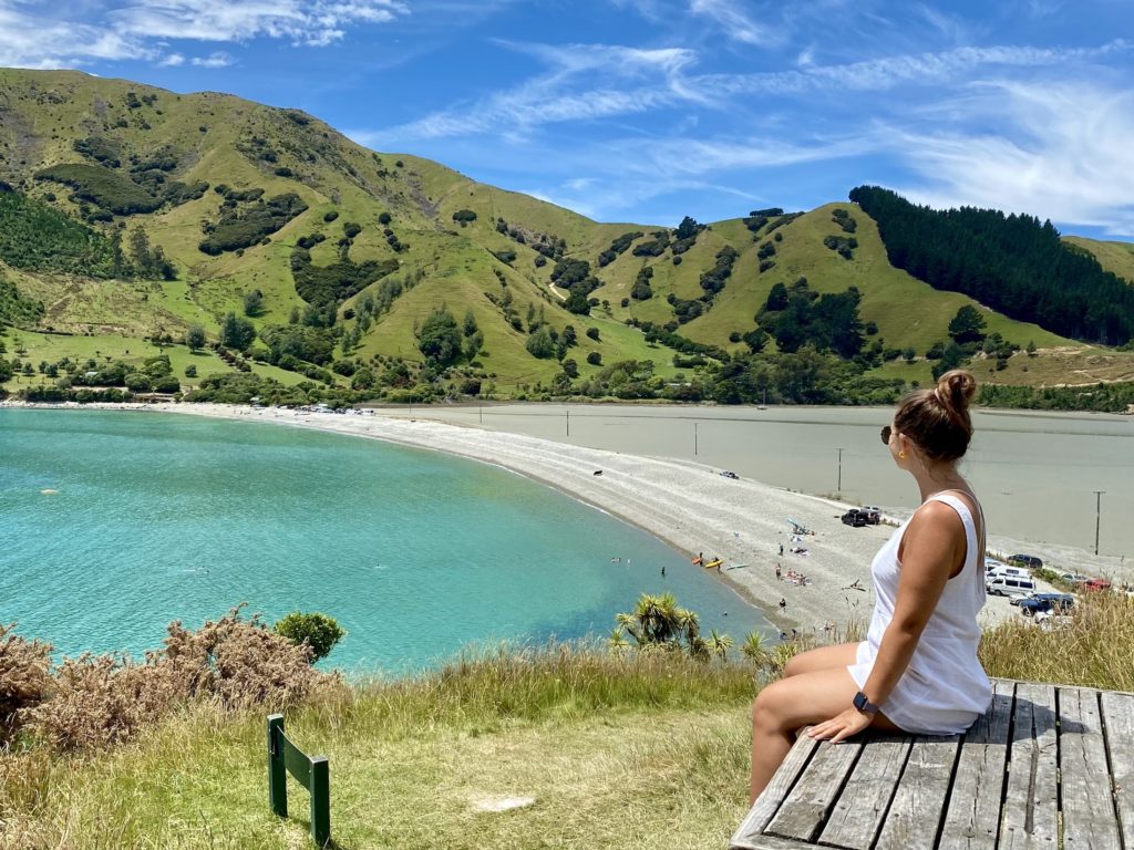 South Island New Zealand road trip: Niki sits in front of Cable Bay, Nelson, New Zealand