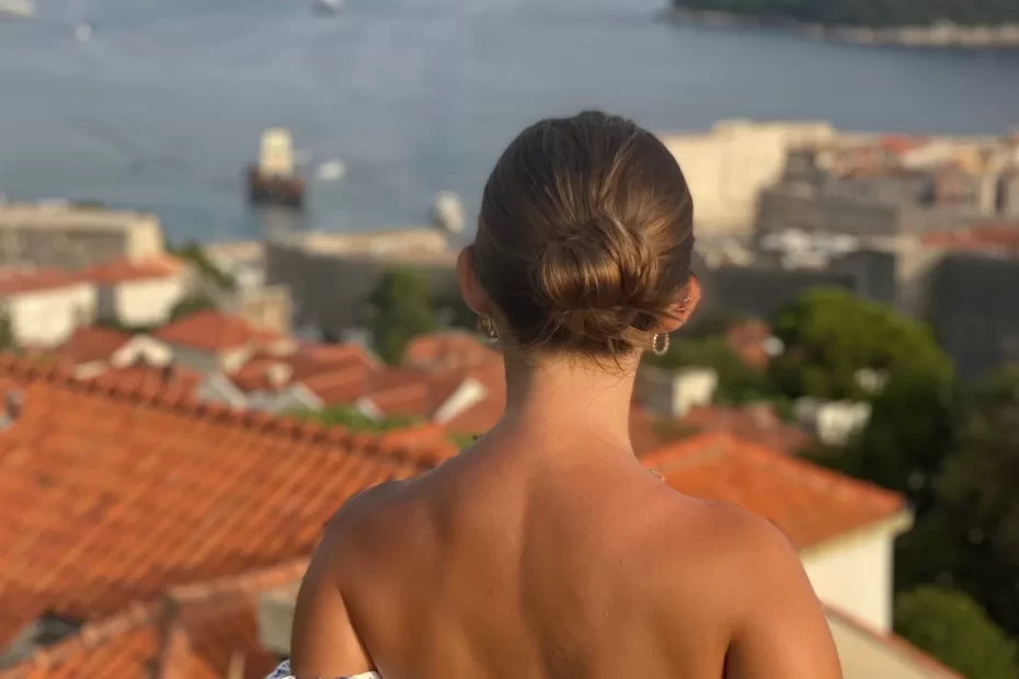 Niki faces away from the camera with a view of Dubrovnik, Croatia's Old Town behind her