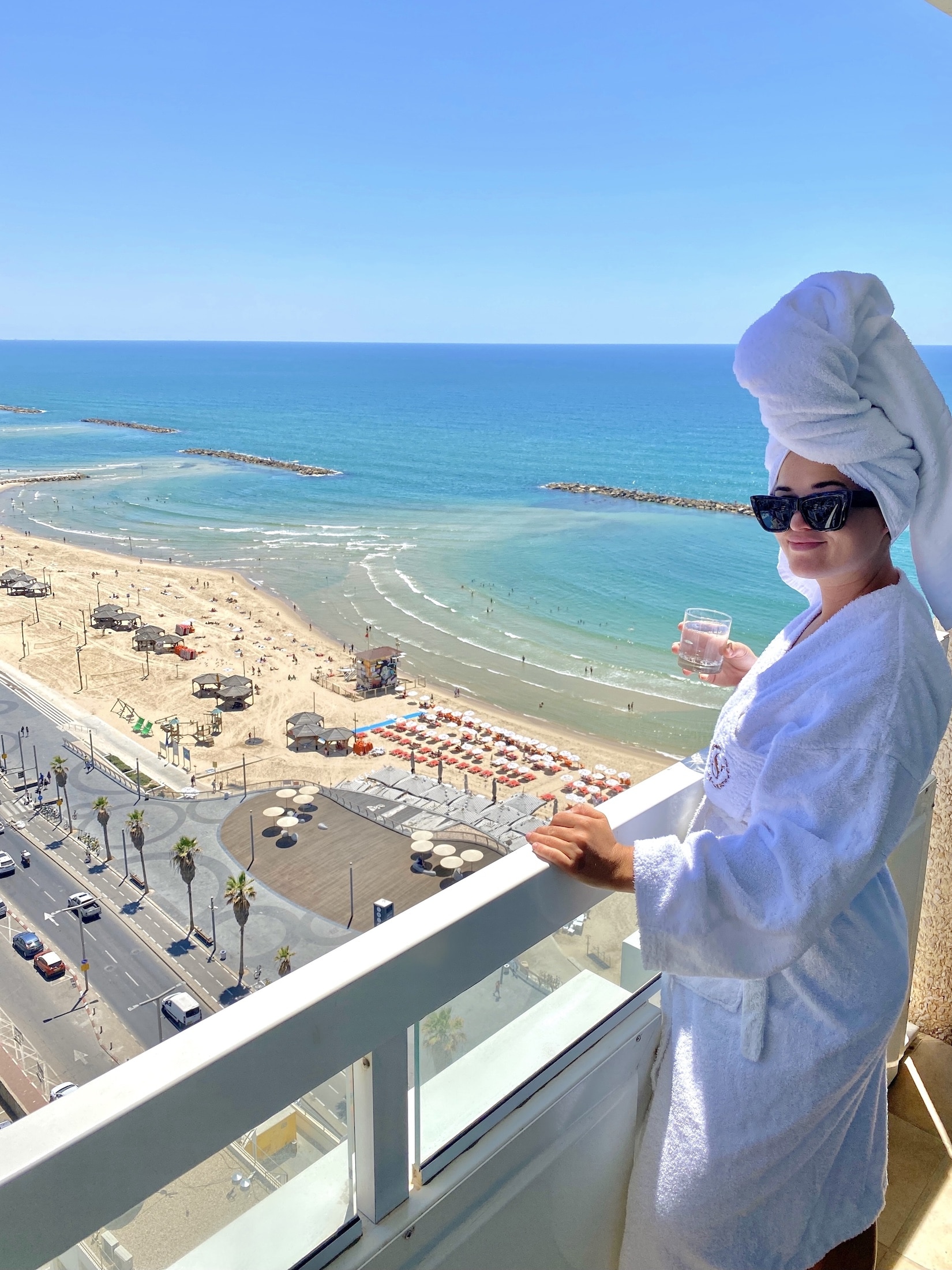 Niki drinks champagne on a balcony in Tel Aviv, Israel