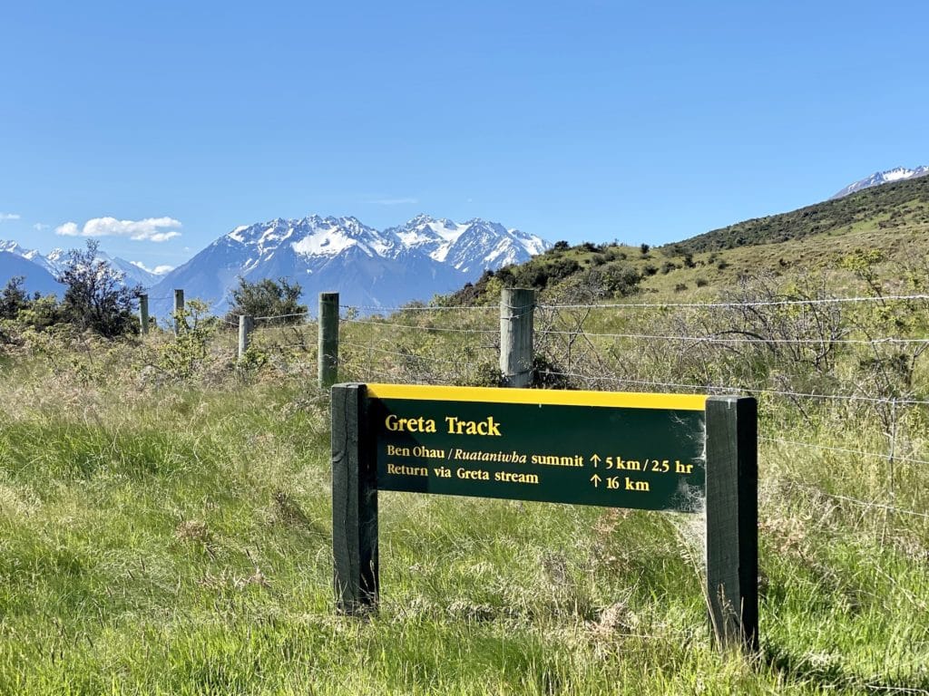 Greta Track signpost with Southern Alps mountains in the distance