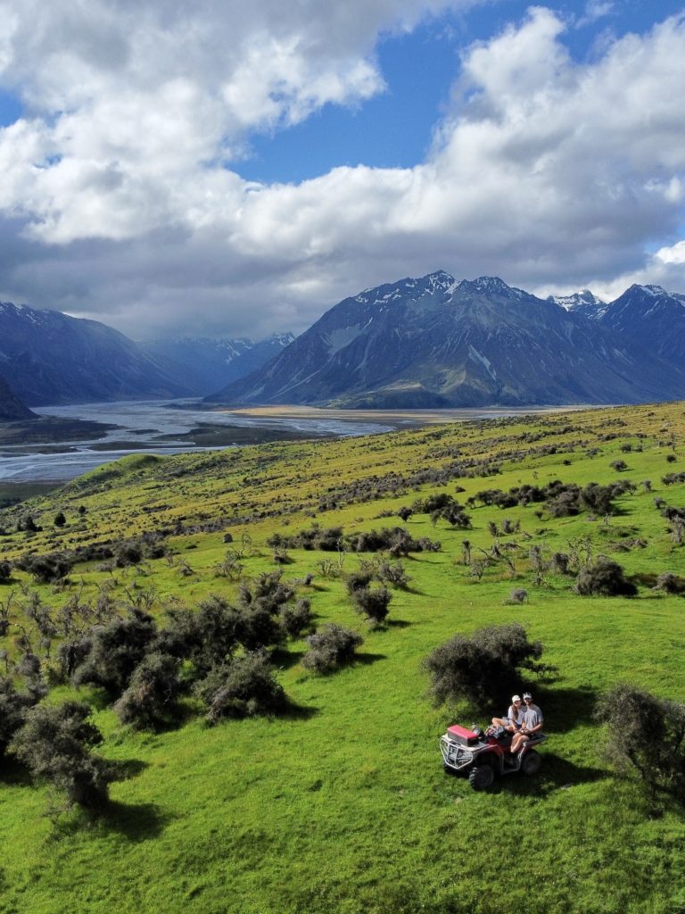 One Second Everyday in 2021: Niki and Ben sit on an ATV with mountains and braided rivers in the background