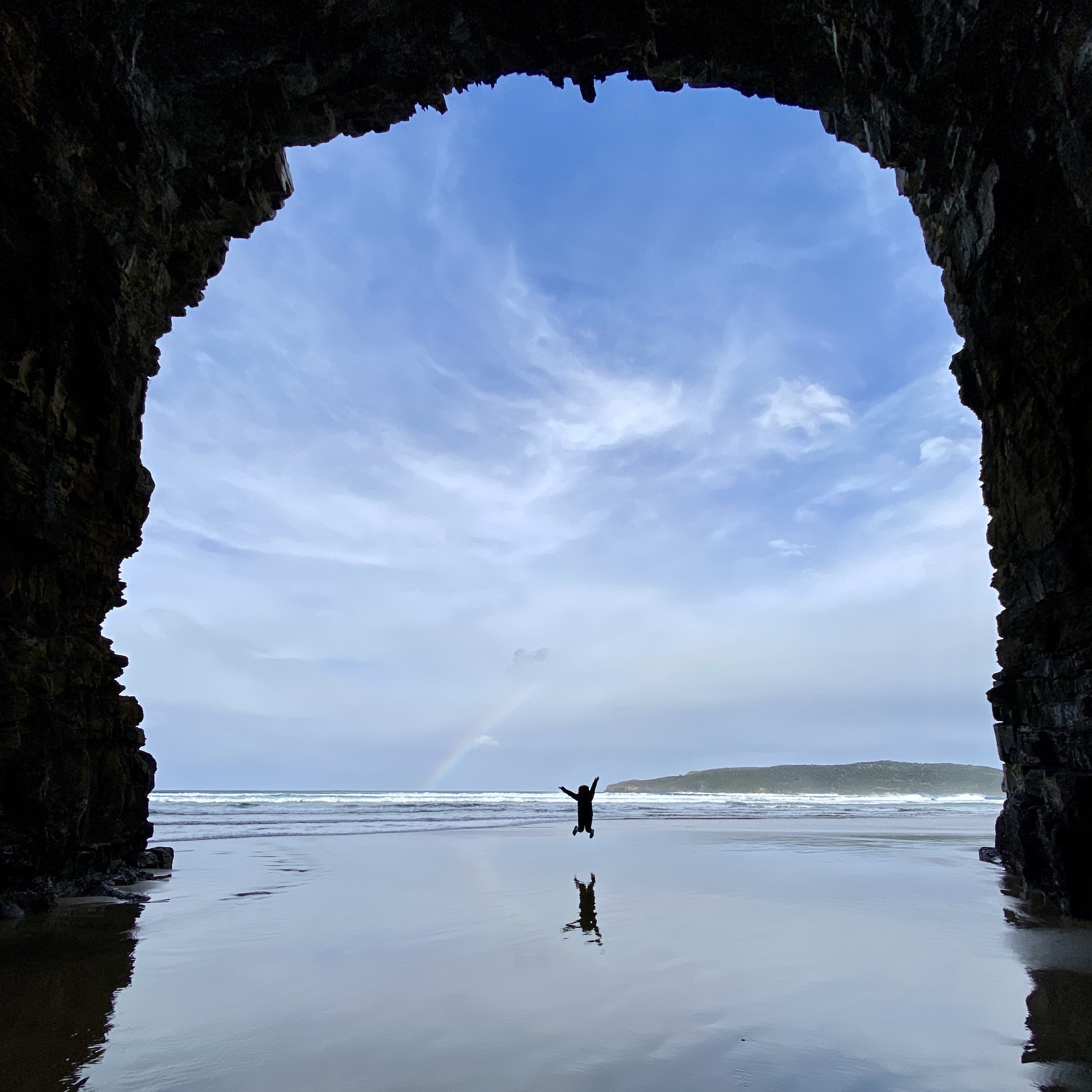 niki jumps in the middle of cathedral caves, the catlins, south island, new zealand