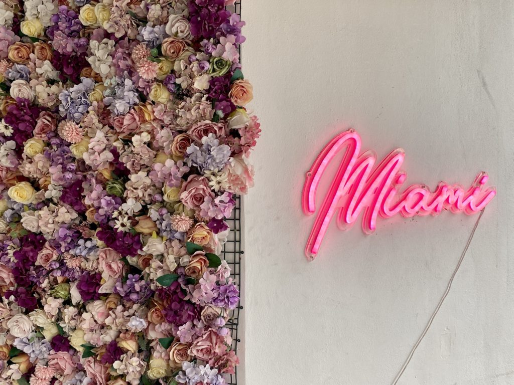 Miami girls trip: Airbnb with fake flower wall and a neon Miami sign, Florida