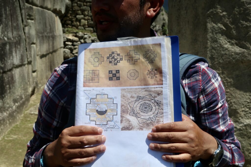 Machu Picchu tour guide holds up informational images, Peru