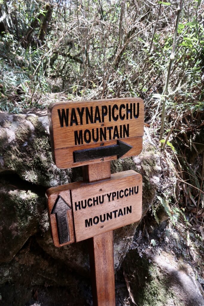 Sign pointing to Waynapicchu Mountain and Huchu'ypicchu Mountain, Peru