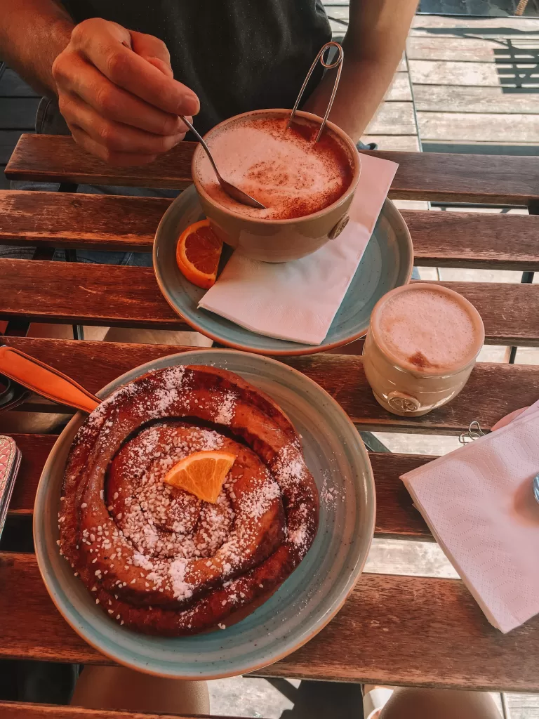 one day in Stockholm: Niki and Ben have a Swedish fika with coffees and a cinnamon bun