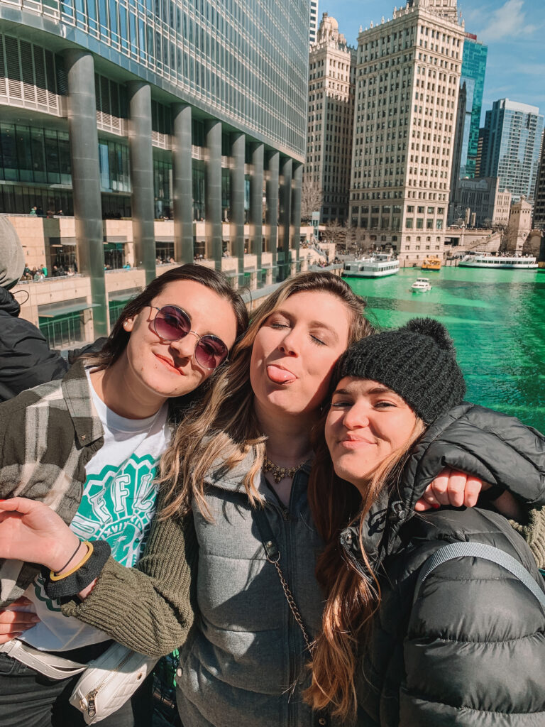 Chicago captions: Niki and friends in front of green Chicago River on St Patrick's Day, Chicago Illinois